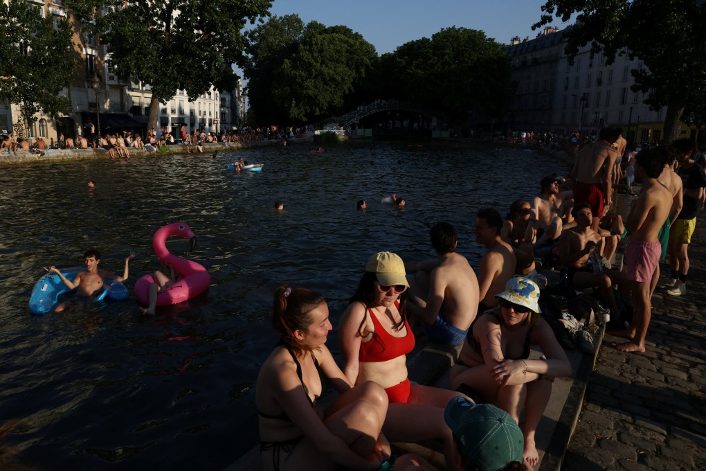 People swim in the Canal Saint-Martin on Friday after public swimming was permitted in certain areas due to high temperatures amid a heatwave in Paris. Photo: Reuters