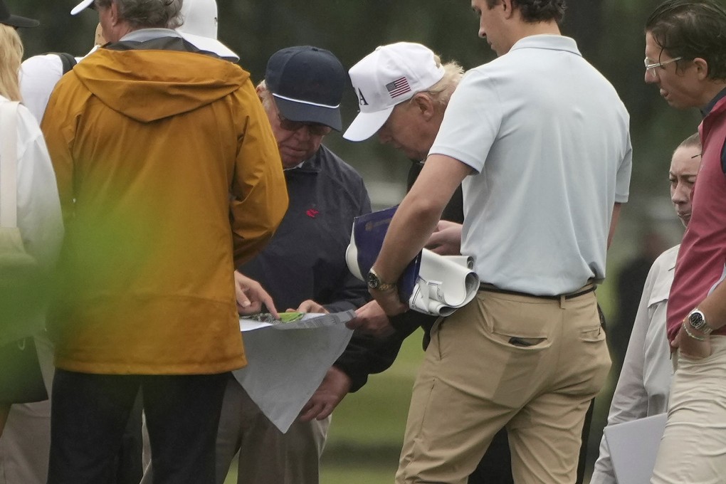 President Donald Trump looks at blueprints while touring the East Potomac Park golf course. Photo: AP