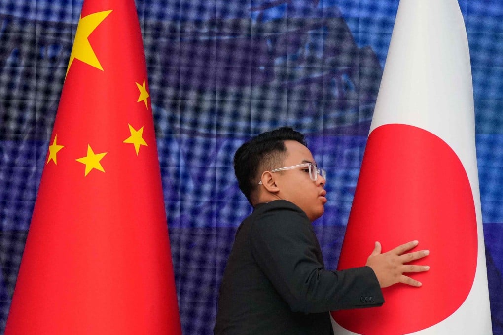 A staff member organises the national flags of China and Japan at talks in Kuala Lumpur in October. Photo: AFP