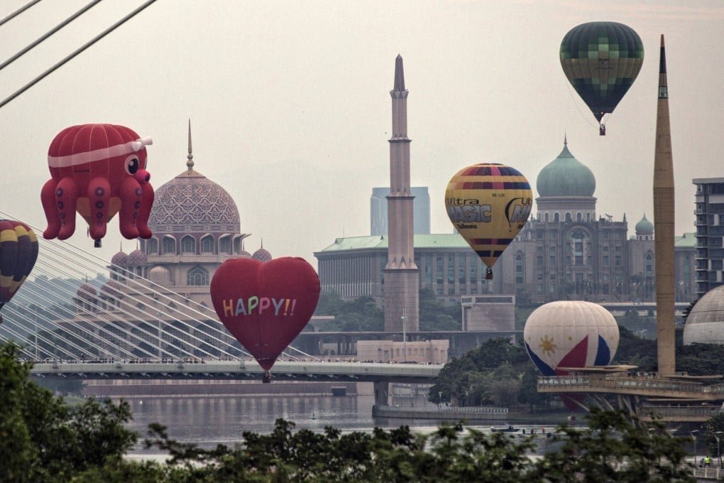 Hot air balloons float near Putra Mosque (left) in Putrajaya, Malaysia. Photo: EPA-EFE