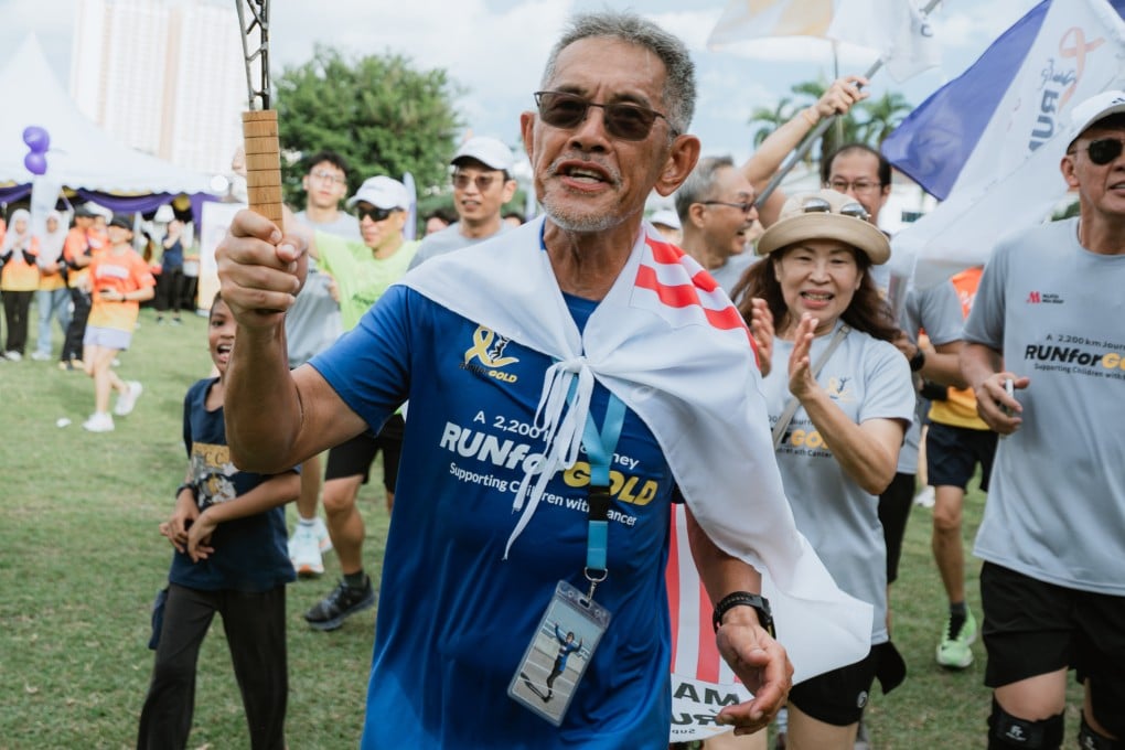 Lim Shyang Guey walks through a crowd after completing his “Run for Gold” campaign, in which he ran 2,200km around Peninsular Malaysia over 86 days in tribute to his wife, who died of gallbladder cancer in 2024. Photo: Michael Tanhy