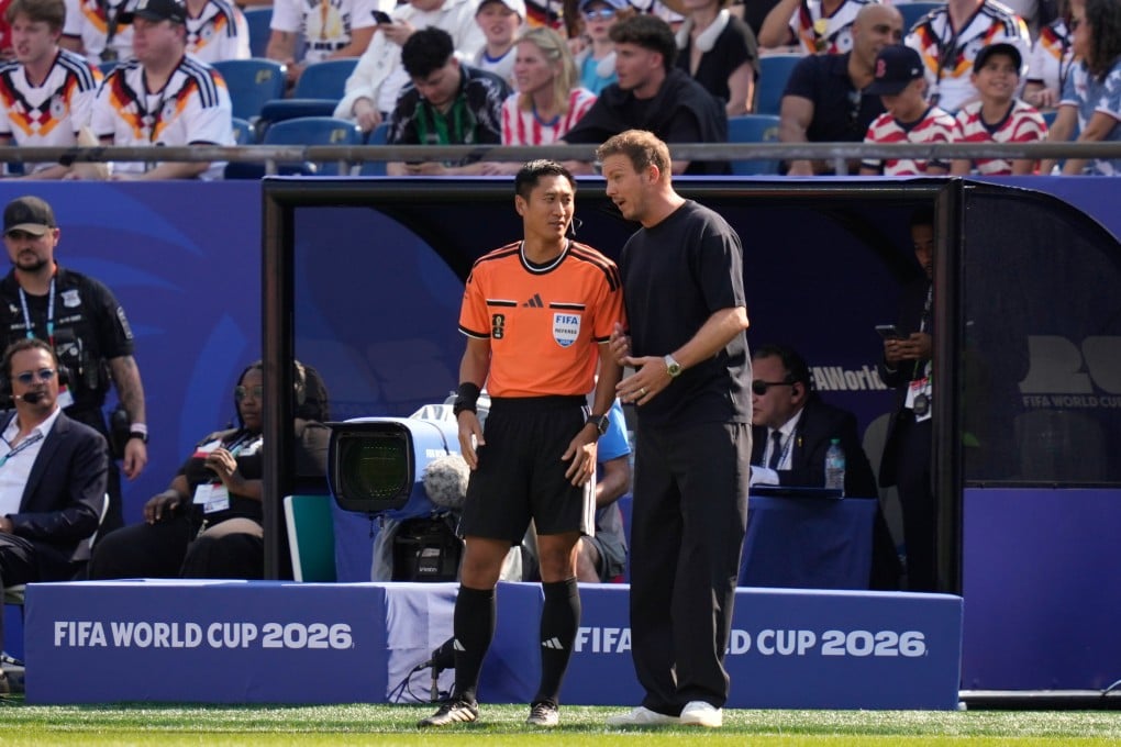 Germany head coach Julian Nagelsmann speaks to fourth official Ma Ning of China during the World Cup match against Paraguay. Photo: AP