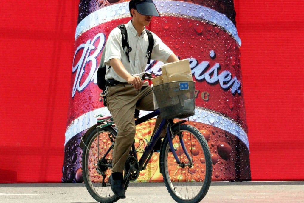A cyclist rides past an advertisement for Budweiser beer in Beijing. Photo: AP