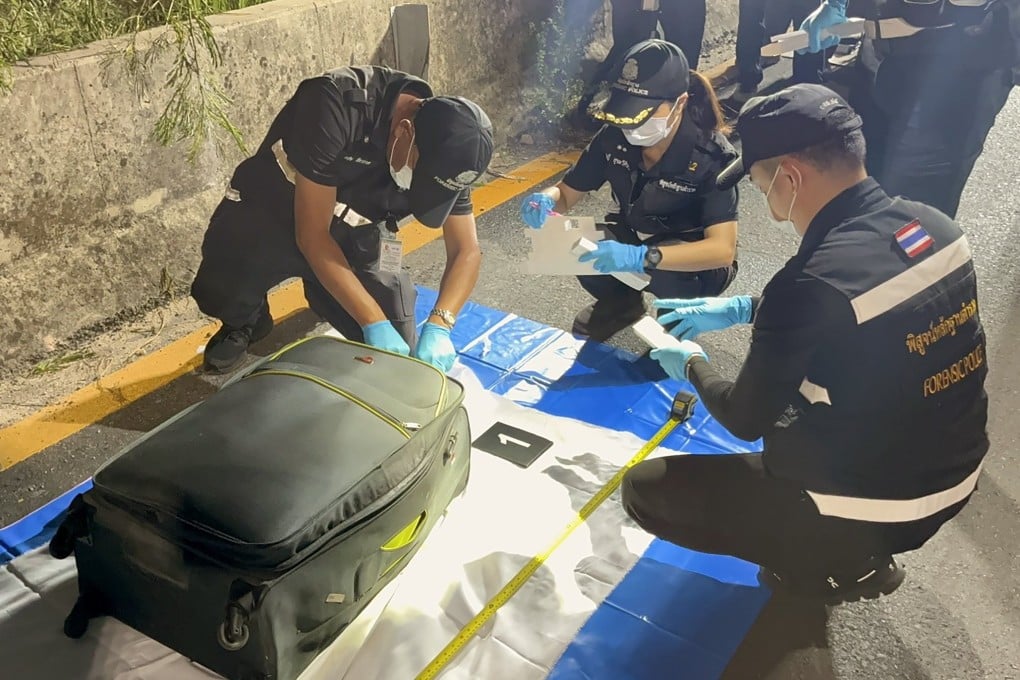 Thai forensic police officers on Friday inspect a suitcase containing the body of a Thai teenage girl believed to have been murdered by an Australian man near a railway track in Pattaya, Thailand. Photo: EPA