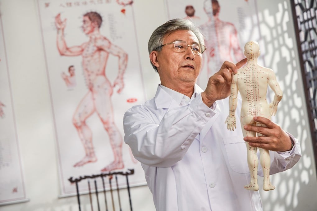 A traditional Chinese medicine doctor looks at a research model of acupuncture points on the human body. Acupuncture is one of several treatments traditionally prescribed in TCM to ensure transitions between later life cycles feel smooth. Photo: Shutterstock