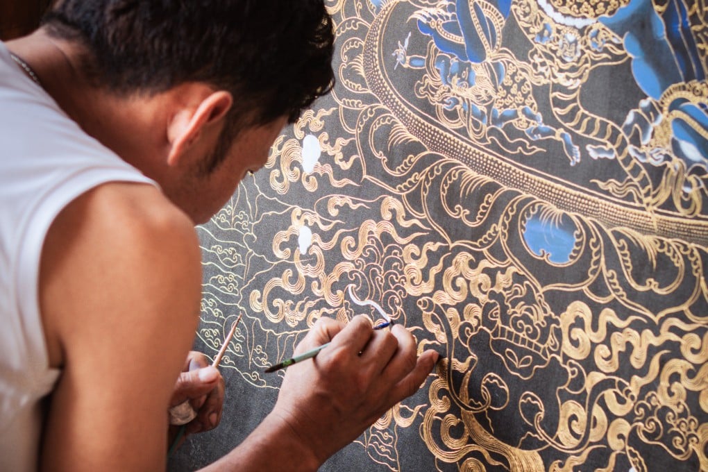 Kinley Tshering paints a thangka of Vajrakilaya, a wrathful deity of Vajrayana Buddhism, Bhutan’s state religion, at the Exotic Art Gallery, in Punakha district, Bhutan. Photo: Jen Paolini