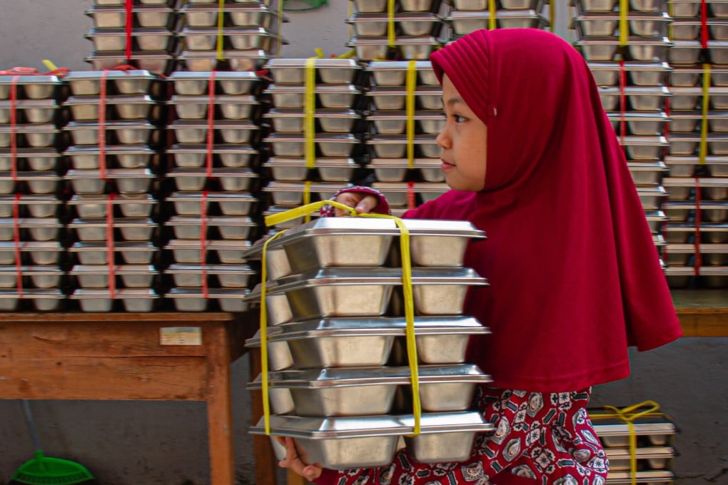 A student carries food trays as part of the free meals programme in Bandung on June 12. Photo: Xinhua
