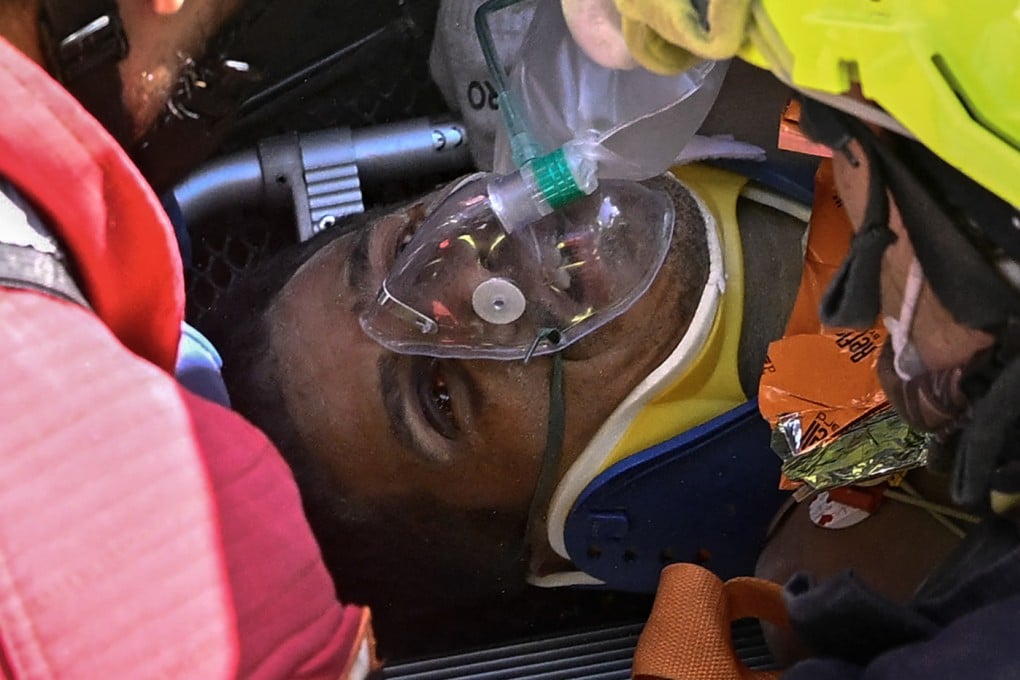 Hernan Gil, a survivor of Venezuela’s twin earthquakes, is helped by rescuers before being rushed into an ambulance in Catia La Mar on Thursday. Photo: AFP