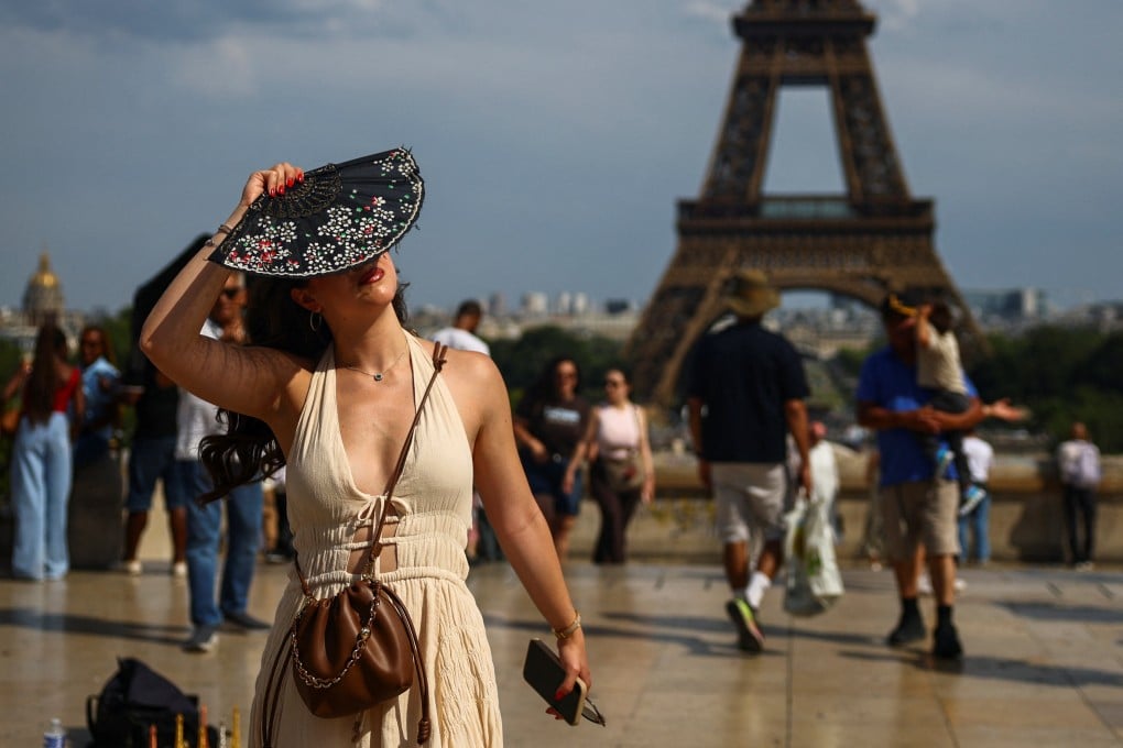 A woman shields her face with a fan in the Trocadero square near the Eiffel Tower in Paris on June 20, during a heatwave affecting a large part of France. Photo: Reuters