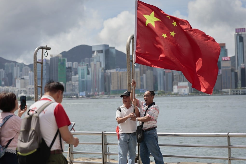 People hold a Chinese national flag at Hong Kong’s Victoria Harbour on July 1, to mark the 29th anniversary of the handover. Photo: EPA