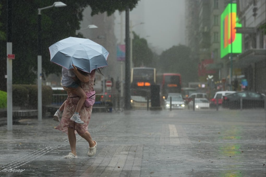 A woman and a child take shelter from strong winds and rain at the Tsim Sha Tsui promenade. Photo: Jelly Tse