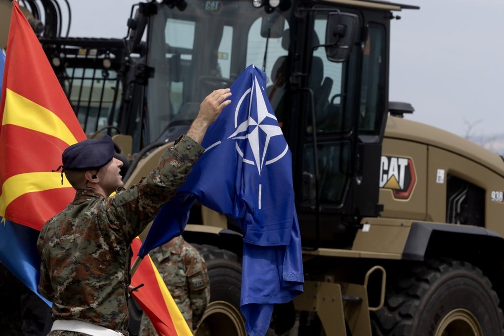 A soldier adjusts the Nato flag during an event in Skopje, Republic of North Macedonia, on Friday. Photo: EPA
