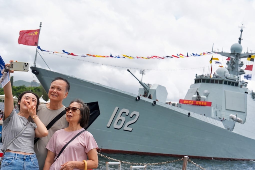 People pose for pictures with two PLA Navy vessels at Ngong Shuen Chau Barracks on July 4. Photo: Elson Li