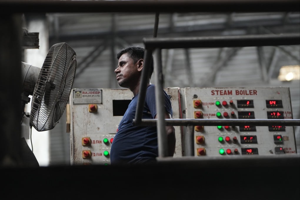 A worker stands in front of a fan on a hot day at a plant near Surat, India, on May 26. Photo: AP