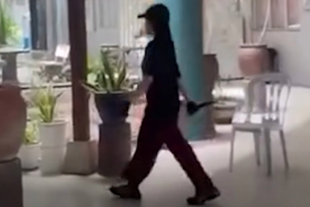 A still from a social media video shows a girl dressed in black walking around the school while holding a knife after the stabbing in Banting, Malaysia, on Monday. Photo: The Star