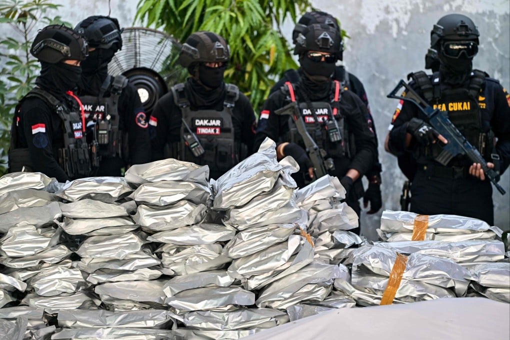 Customs officers stand next to packages of seized cannabis buds during a press conference in Gresik, Indonesia’s East Java province, on Thursday. Photo: AFP