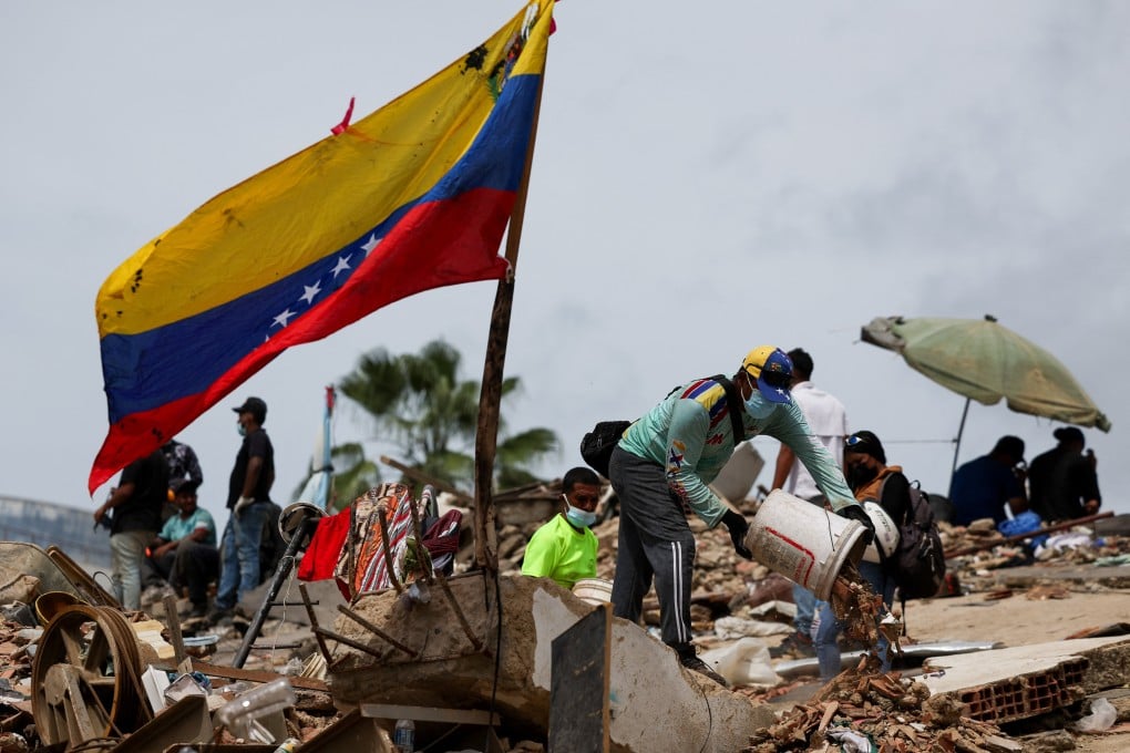 A Venezuelan flag flutters as rescuers work at the site of a collapsed building in the aftermath of the June 24 earthquakes, in La Guaira, Venezuela on Sunday. Photo: Reuters