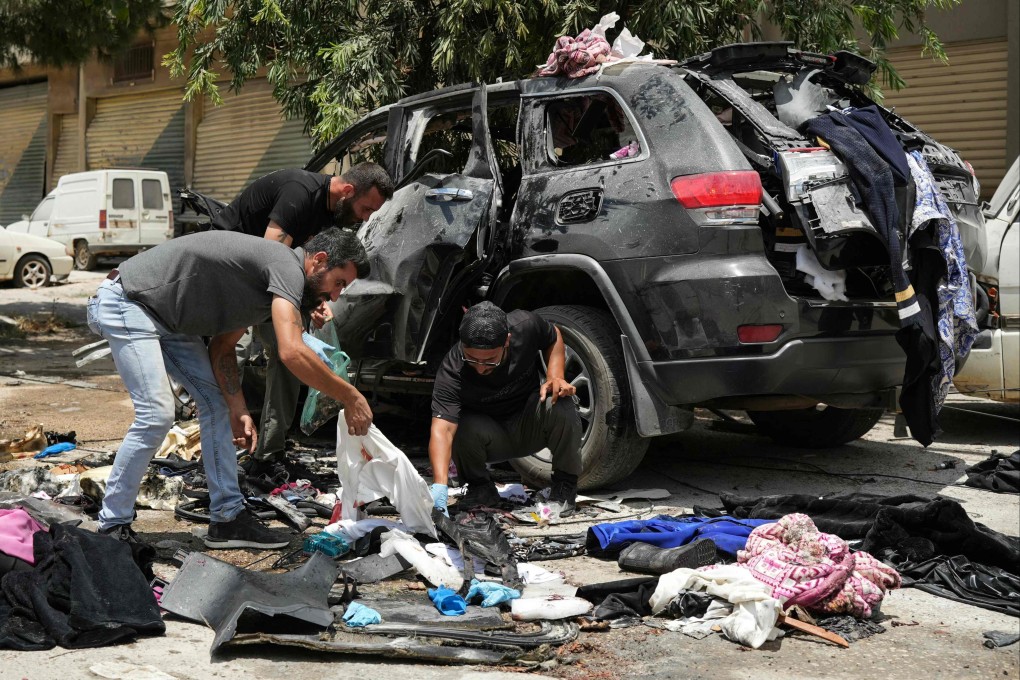 First responders inspect the wreckage of a car reportedly targeted by an Israeli strike in Nabatieh, Lebanon on Monday. Photo: AFP