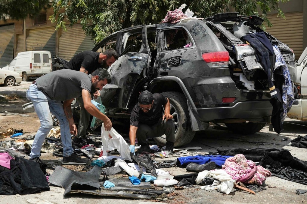 First responders inspect the wreckage of a car reportedly targeted by an Israeli strike in Nabatieh, Lebanon on Monday. Photo: AFP