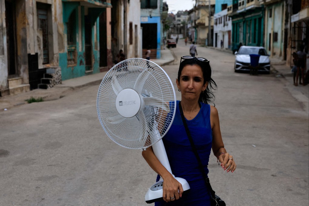 A woman walks on a street in Havana carrying a fan as Cuba endures another power failure. Photo: Reuters