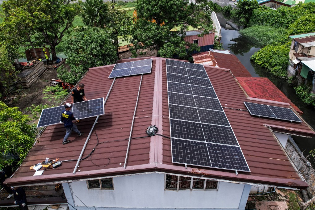 Workers install solar panels on the roof of a house in Kawit, the Philippines, on June 26. Photo: Reuters