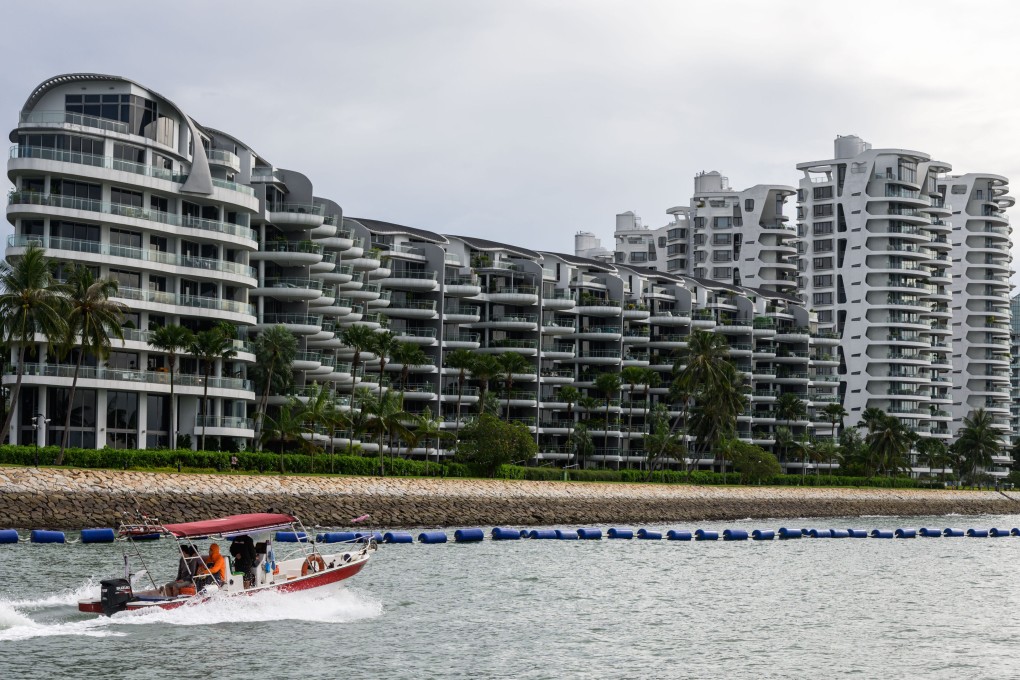 A small motor boat passes by luxury waterfront condominiums in Singapore’s Sentosa Cove. Photo: Getty Images