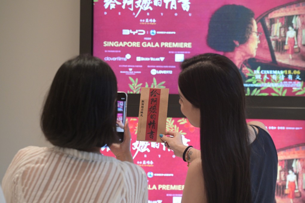 Women take a photo with “Dear You” posters during its premiere in Singapore on June 17. Photo: Xinhua