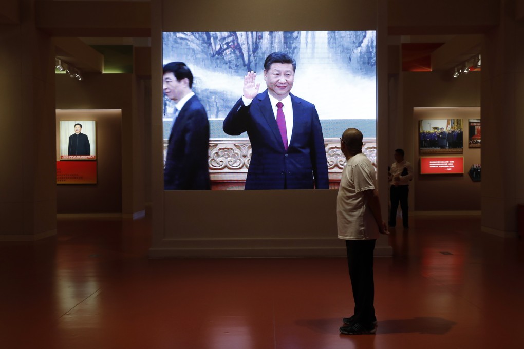 A visitor looks at a screen showing President Xi Jinping at an exhibition commemorating China’s Communist Party history and achievements, on October 1, 2019. Photo: EPA-EFE