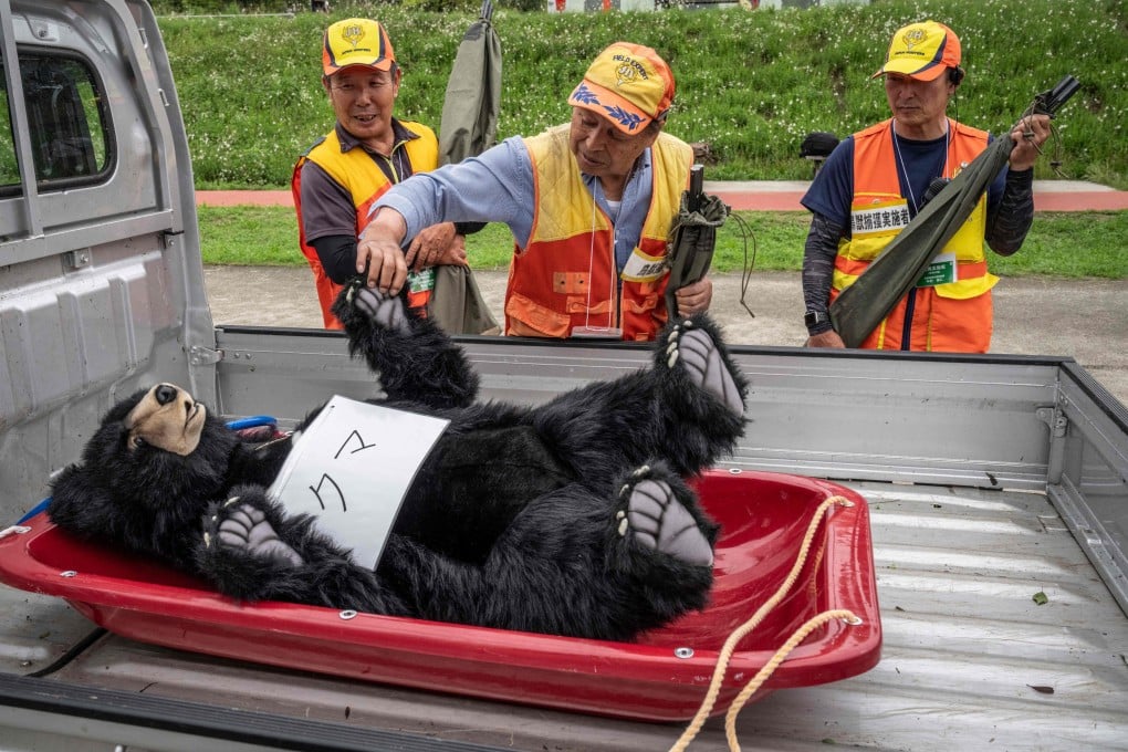 A local hunter touches a bear dummy during an emergency response drill for bear and other wildlife intrusions in Isehara, Kanagawa prefecture, Japan on July 3. Photo: AFP