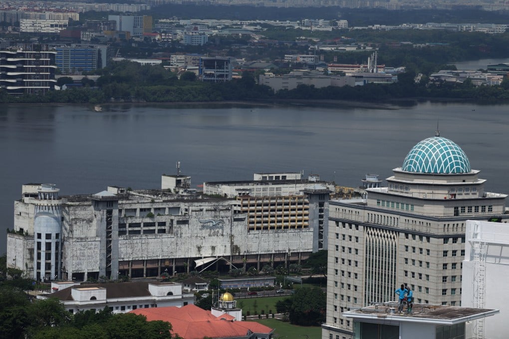 Workers repair a rooftop next to the Strait of Johor separating Singapore and Malaysia, in Johor Bahru, Malaysia on Monday. Photo: Reuters