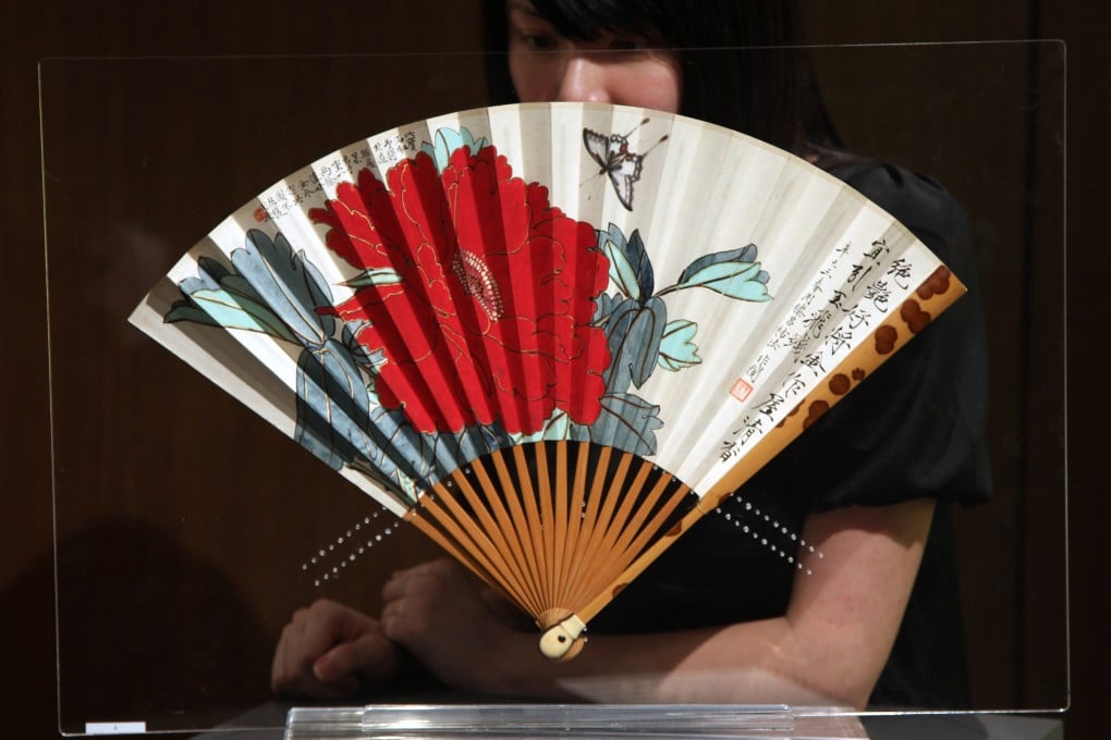A folding fan painted by Chinese artist Yu Feian (1889-1959) at an auction preview at Sotheby’s Hong Kong in 2010. As well as helping to beat the summer heat, fans have been used in China for centuries to mark status and as works of art. Photo: Sam Tsang