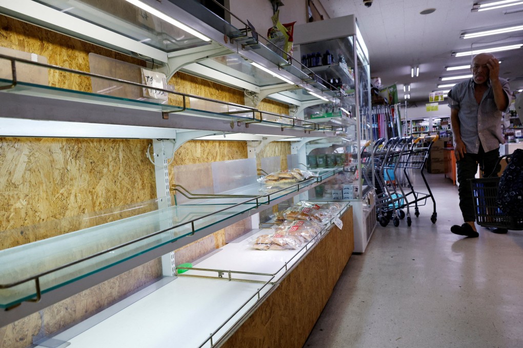 A man looks around the partly empty shelves of bread at a supermarket, as Super Typhoon Bavi approaches Ishigaki, Japan, on Friday. Photo: Reuters