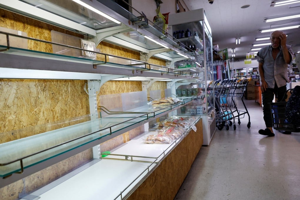 A man looks around the partly empty shelves of bread at a supermarket, as Super Typhoon Bavi approaches Ishigaki, Japan, on Friday. Photo: Reuters