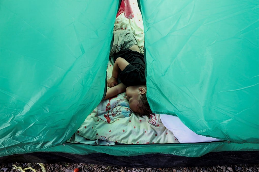 A child sleeps inside a tent in a makeshift shelter in the aftermath of the June 24 earthquakes. Photo: Reuters