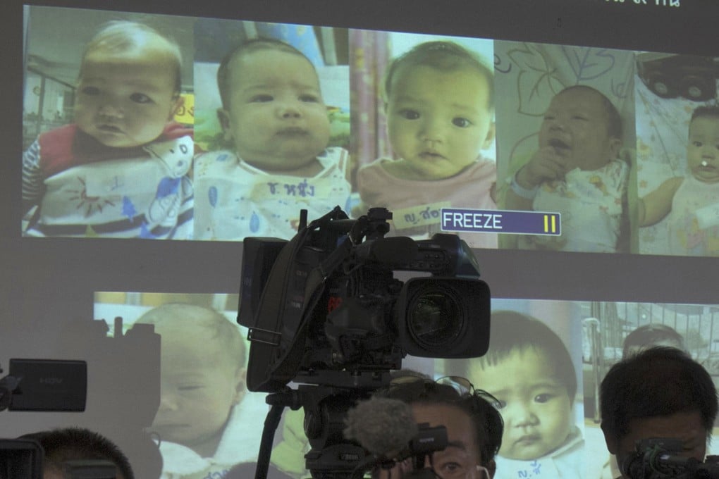 Media attend a press briefing where Thai police showed pictures of surrogate babies in 2014, the year before Thailand banned commercial surrogacy. Photo: AP