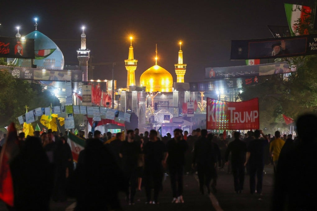 Mourners walk past an anti-US banner as they arrive for the funeral of slain Iranian leader Ali Khamenei in Mashhad on Thursday. Photo: AFP