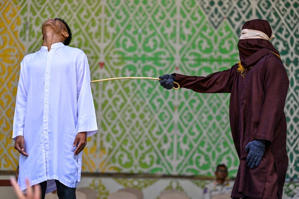 A man convicted of having sex outside marriage receives 100 lashes from a member of the sharia police during a public caning in Banda Aceh, Indonesia, on May 21. Photo: AFP