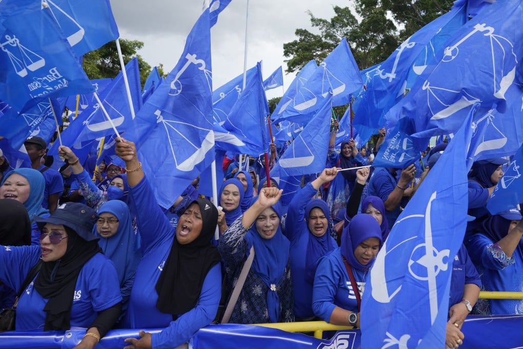 Barisan National supporters wave flags outside a nomination centre during Malaysia’s 2022 election. Photo: AP