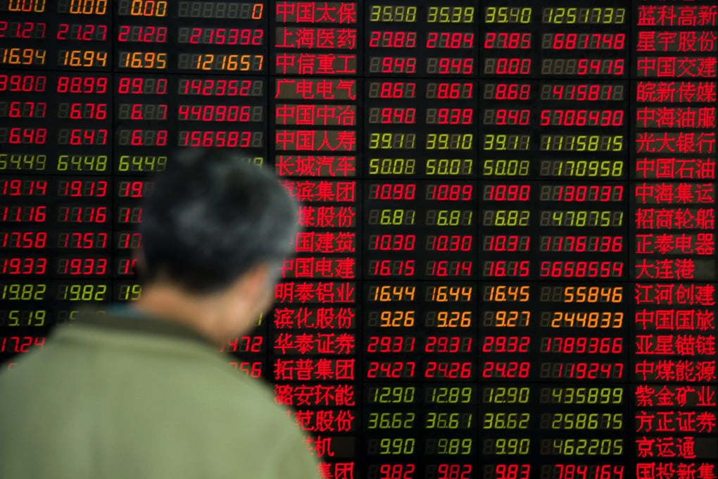 A man in front of a stock exchange board in Shanghai, China. Photo: Getty Images