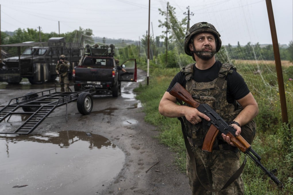 A Ukrainian soldier standing guard beside an unmanned ground vehicle (UGV) carrying ammunition, water and provisions in the frontline city of Druzhkivka, Donetsk region, Ukraine, on Friday. Photo: EPA