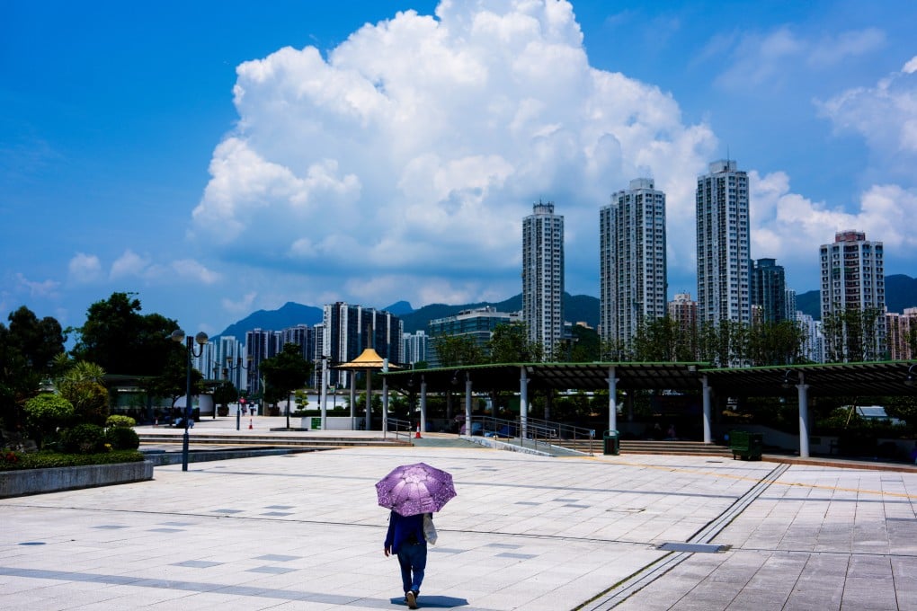 A lone pedestrian holds an umbrella to guard against the scorching sun in Sha Tin. The Observatory issued a “very hot weather” warning on Sunday due to the outer subsiding air of Typhoon Bavi, which made landfall in eastern China on Saturday night. Photo: Sam Tsang