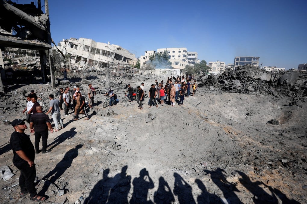 Palestinians inspect the site of an Israeli strike on a metal foundry in Gaza City on Sunday. Photo: Reuters