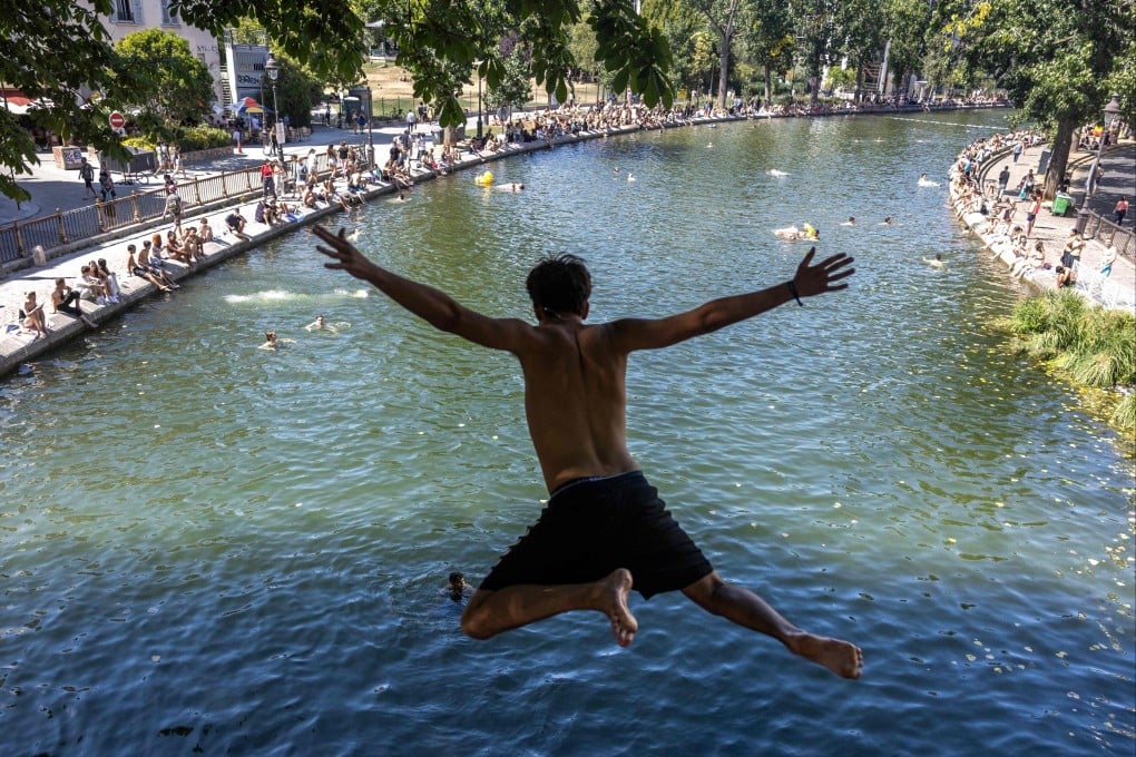 A man jumps from a bridge into the Canal Saint-Martin in Paris on July 12. Photo: AFP