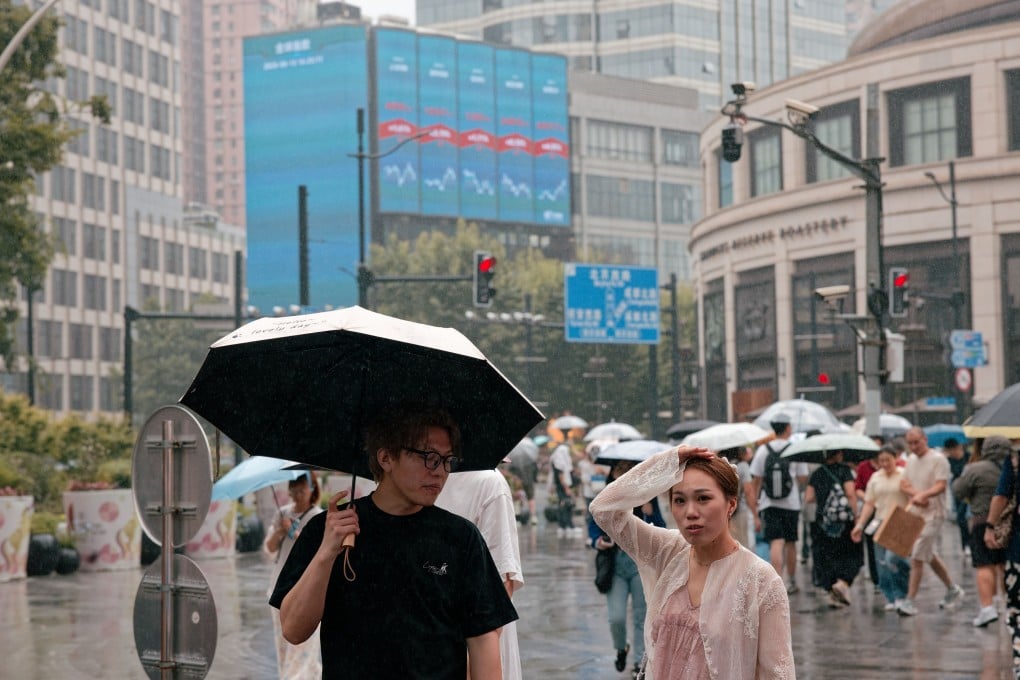 Pedestrians beneath a large screen showing the latest stock market and economic data in Shanghai on June 15. Photo: EPA