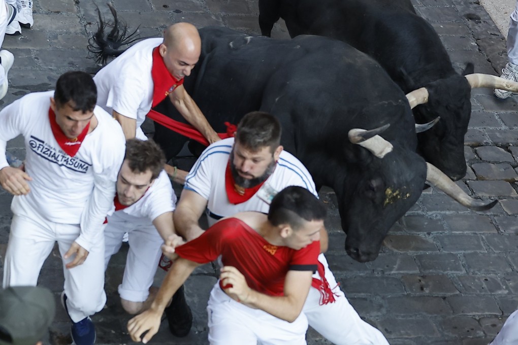 Runners are chased by bulls from the Jandilla ranch during the final run of the San Fermin festival in Pamplona on Tuesday. Photo:   EPA