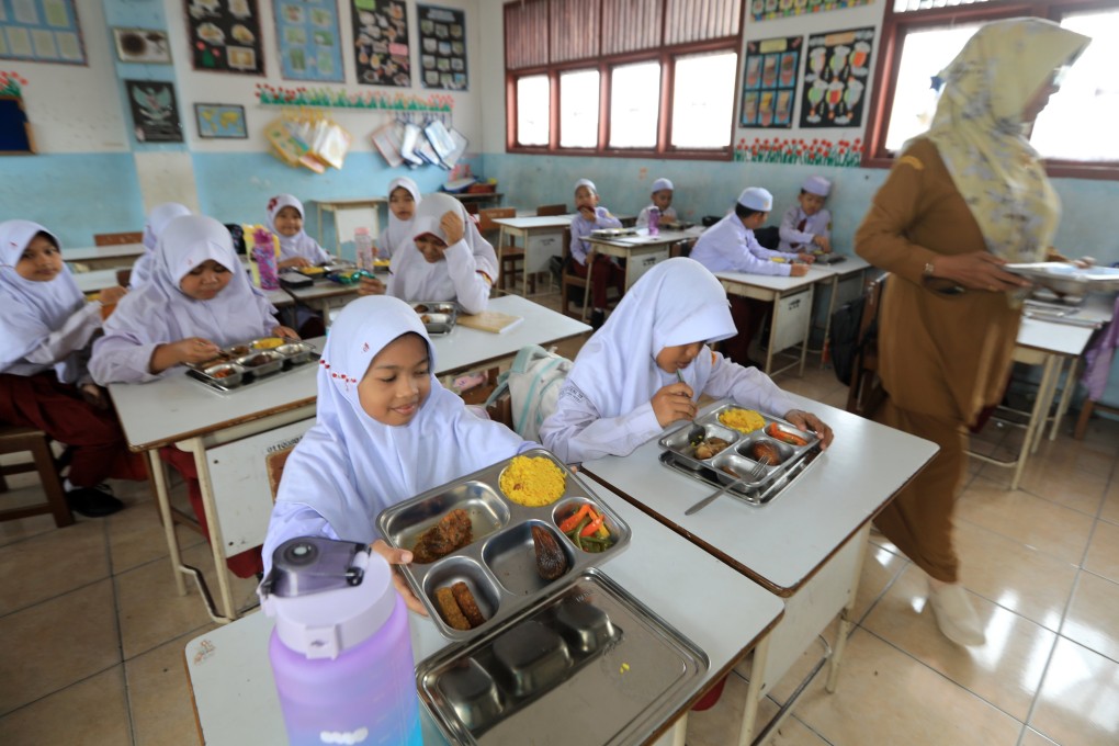 Indonesian students eat their free meals at a primary school in Banda Aceh on March 31. Photo: EPA