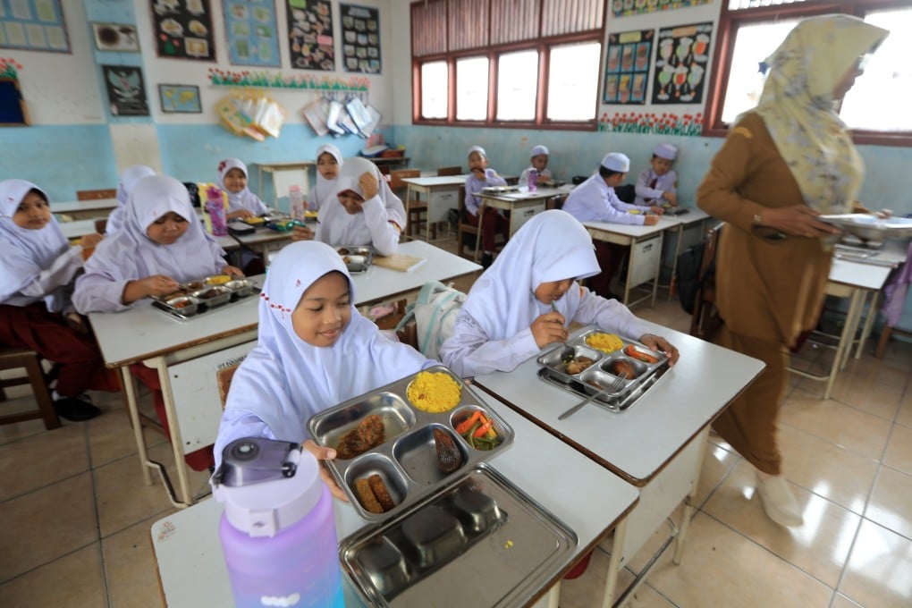 Indonesian students eat their free meals at a primary school in Banda Aceh on March 31. Photo: EPA