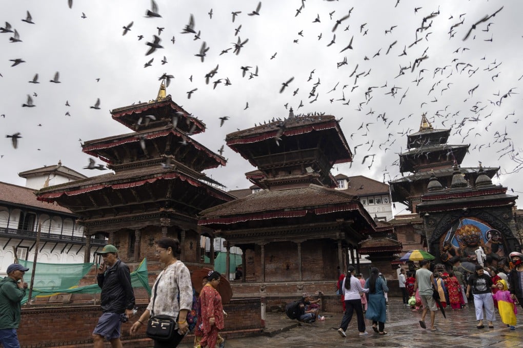 People walk as pigeons fly over Kathmandu Durbar Square in Kathmandu, Nepal, on Monday. Photo: EPA