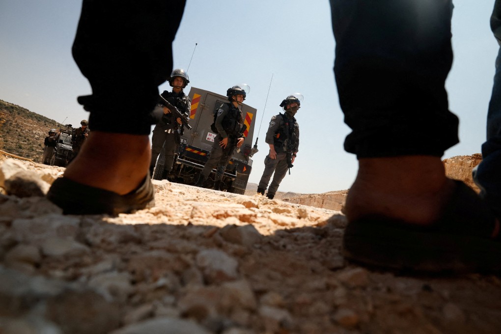 Israeli officers stand in front of Palestinians during a protest against a new Israeli settlement in the village of Deir Abu Mishal, near Ramallah, in the Israeli-occupied West Bank. Photo: Reuters