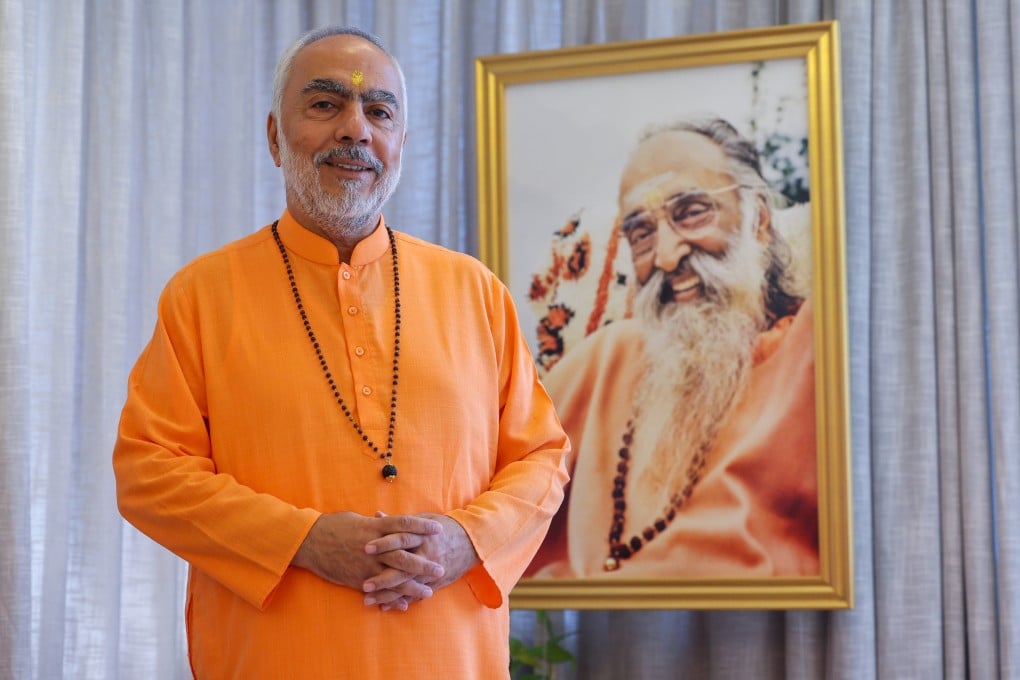 Chinmaya Mission head Swami Swaroopananda in Tsim Sha Tsui, Hong Kong, next to a portrait of Swami Chinmayananda. Swaroopananda grew up in Hong Kong and was back recently for a spiritual gathering celebrating his mission’s 75th anniversary. Photo: Edmond So